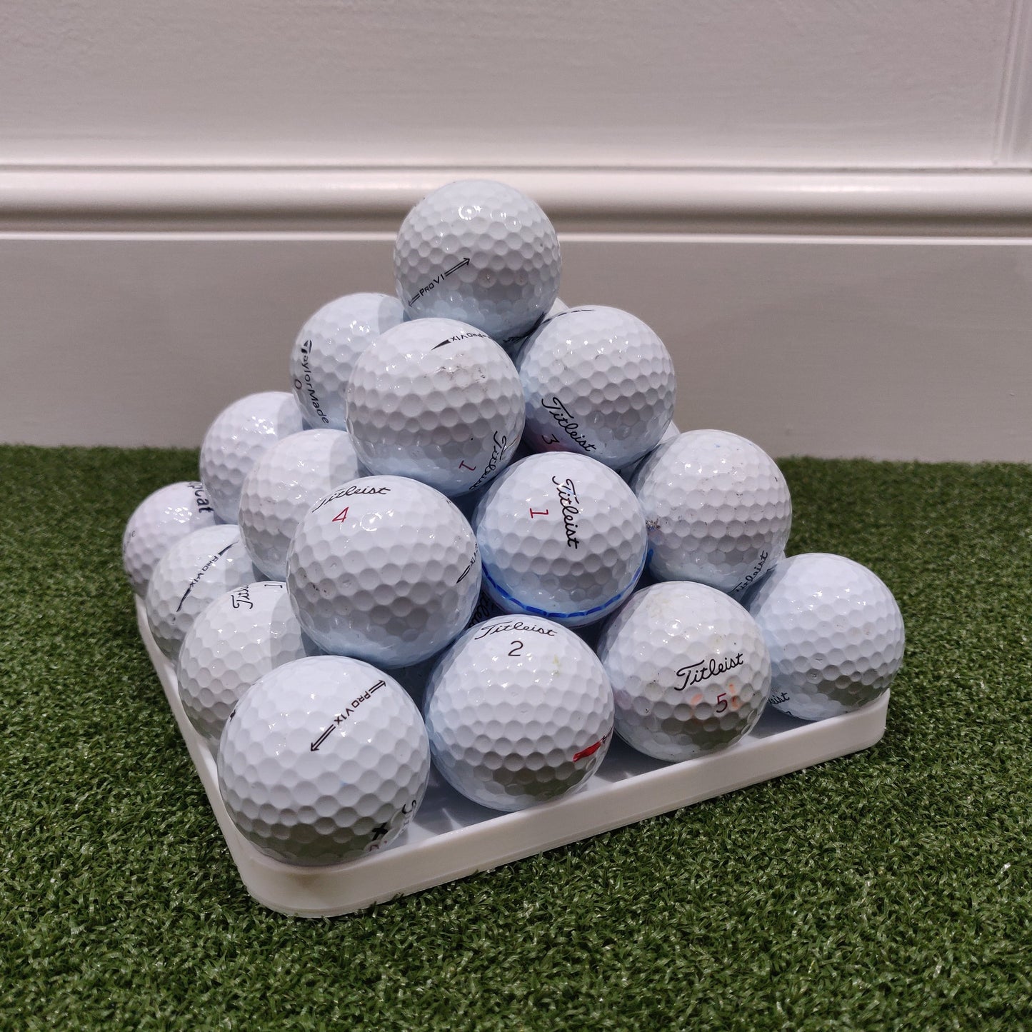 Stack of golf balls on a tray with a white background